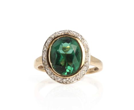 A 9ct gold oval cluster ring,an oval mixed cut green quartz, possibly synthetic, rub set to a surround of eight cut diamonds,