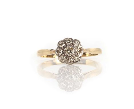 A gold diamond flowerhead cluster ring,set with a transitional cut diamond within a surround of eight cut diamonds, all bead 