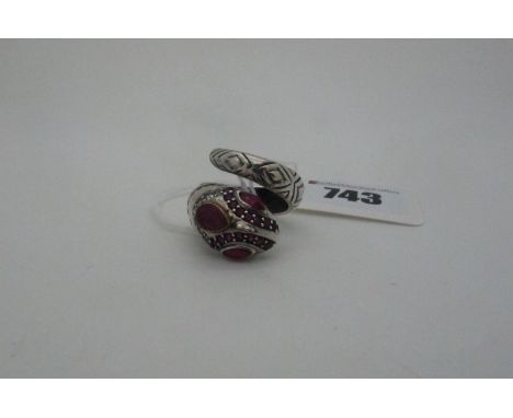 A Modern Ruby Set Serpent Dress Ring, of coiled design, with textured detail and inset highlights (approximate finger size P)