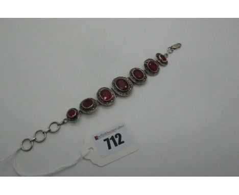 A Modern Ruby Set Bracelet, of graduated oval design, collet set with scroll detail, clasp stamped "925".  