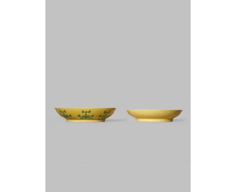 TWO CHINESE YELLOW GROUND SAUCERS YONGZHENG AND QIANLONG One carved to the exterior with flowerheads on a continuous scrollin