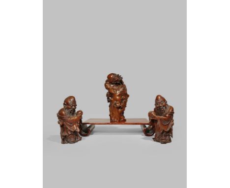 THREE CHINESE HARDWOOD CARVINGS OF IMMORTALS 20TH CENTURY Two of Shoulao, standing wearing long robes and holding peaches, th
