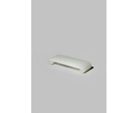 A CHINESE WHITE JADE BRUSH REST 19TH CENTURY Carved as a miniature scroll-end table from stone of even colour, 7.5cm.