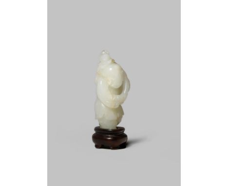 A CHINESE PALE CELADON JADE CARVING OF A BOY QING DYNASTY Carved with his head turned to one side, carrying a lotus blossom o