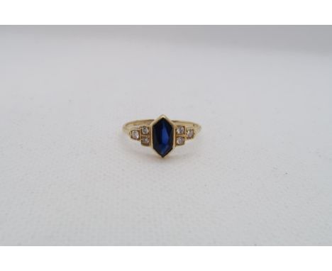 A sapphire (possibly synthetic) ring set in yellow gold (tested as approx 18ct) with diamond set shoulders - ring size N - ap