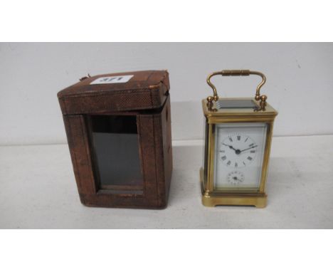 A brass cased alarm carriage clock with alarm - approx 9cm x 5cm x 6cm - working in saleroom - with leather and glass travell