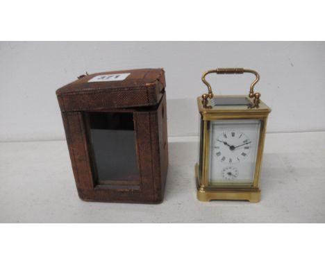 A brass cased alarm carriage clock with alarm - approx 9cm x 5cm x 6cm - working in saleroom - with leather and glass travell