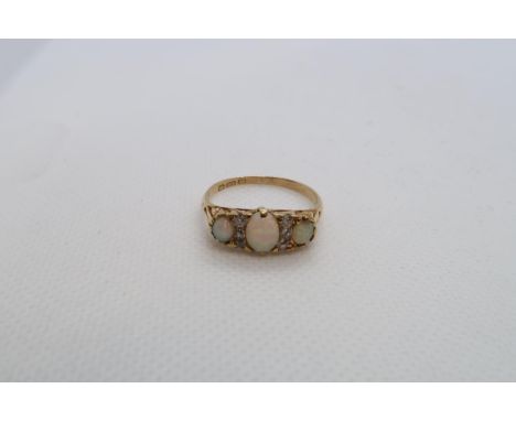 An 18ct yellow gold graduated opal and diamond accent bridge ring size R - weight approx 3.7 grams 