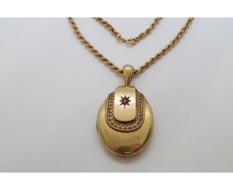 A Victorian yellow gold locket with red garnet, 6cm, with ring, on 9ct yellow gold hallmarked chain, 49cm long, approx 10.8 g