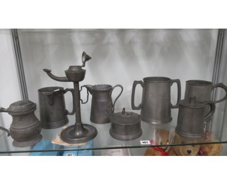 Eight items of antique Pewter including an oil lamp, jugs and a twin handle mug inscribed HMS Britannia 