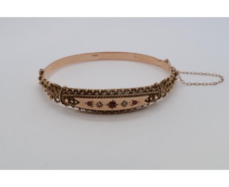 A late Victorian / Edwardian 'Etruscan' 9ct red gold hallmarked hinged bangle bracelet with diamond, ruby, and garnet, approx