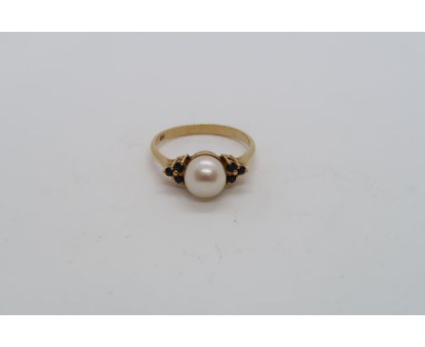 An 18ct hallmarked yellow gold ring with central pearl triple setting sapphire shoulders, size L, approx 2.6 grams 