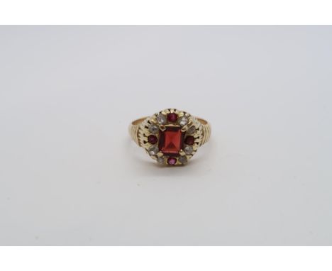 An 18ct yellow gold hallmarked garnet and diamond ring, central emerald cut red garnet set with rose and old cut diamonds and