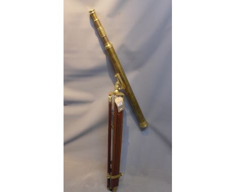 An early 20th Century brass telescope raised on adjustable mahogany tripod base