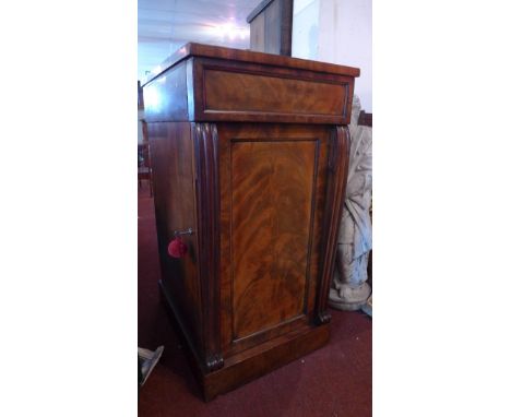 A William IV mahogany cellarette/ cabinet having cupboard door with reeded columns enclosing a drawer above shelf space and a