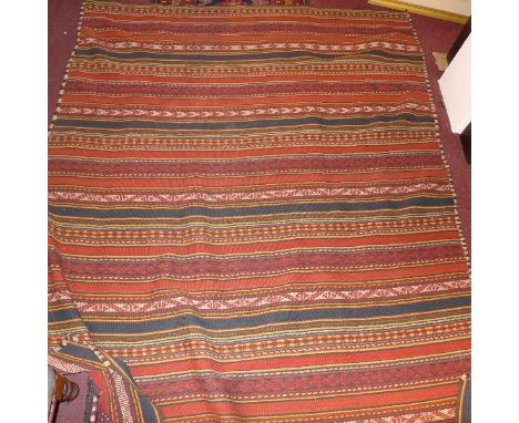 A kelim carpet with striped geometric design on a red ground. 193x161cm