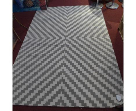 A contemporary grey and white woolen carpet with zig zag designs, 231cm x 160cm