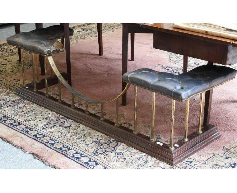 An Early 20th Century Club Fender, with buttoned leather corner cushions on a brass rail over a moulded mahogany curb, 163cm,
