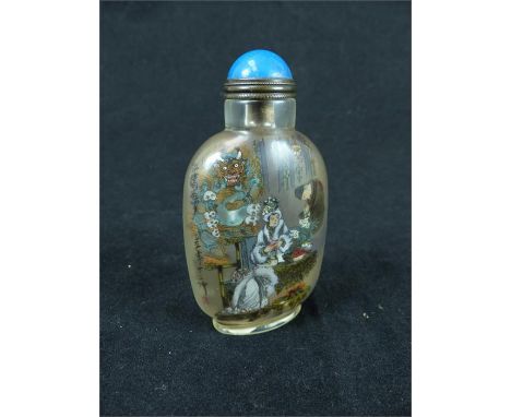 An early/mid 20th century hand painted Chinese glass snuff bottle depicting a seated woman and gentleman in a lavish interior