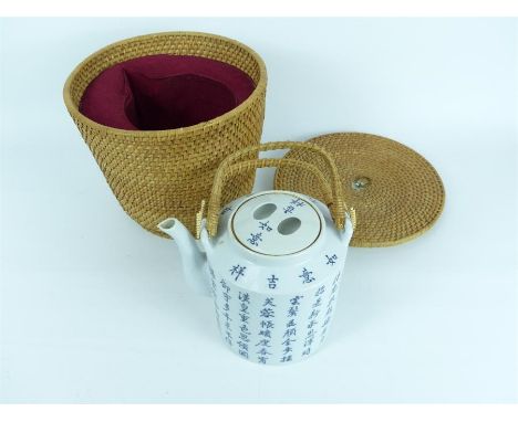 An unusual early 20th century Chinese teapot in original fitted wicker basket, featuring a white ground decorated with blue C