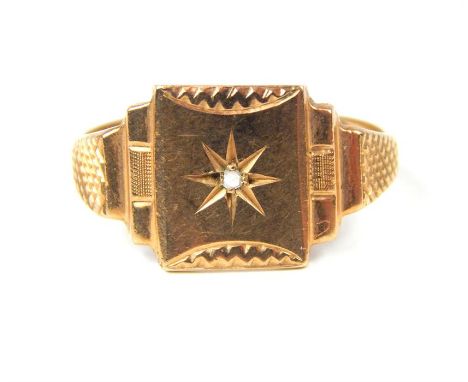 A 9 ct yellow gold signet ring centrally set with a diamond and featuring a stepped, geometric design with engraved star and 