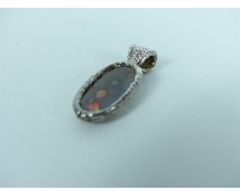 A striking, boxed, elongated Australian boulder opal pendant set in a bezel- mounted, textured silver mount with textured sil