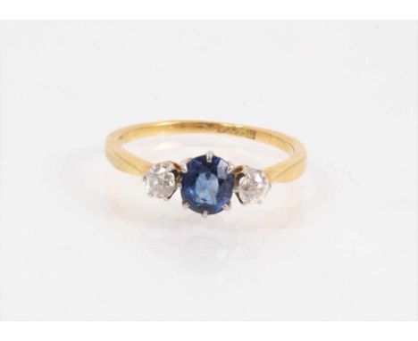 18ct gold sapphire and diamond three stone ring with a central oval mixed cut blue sapphire flanked by two old cut diamonds, 