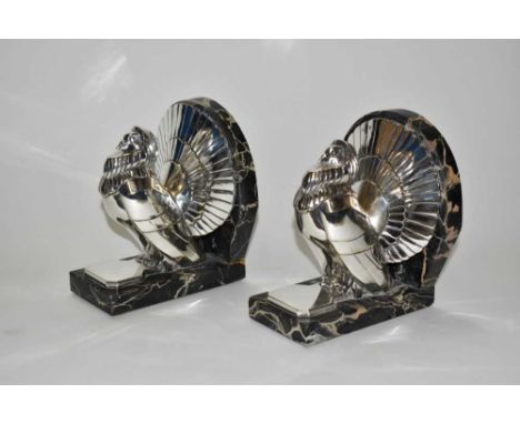 A pair of Art Deco silvered bronze bookends cast from a model by C. Charles, modelled as fan tailed doves on veined marble ba
