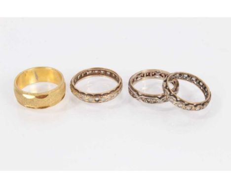 Two 9ct gold gem set eternity rings, one other similar 9ct gold and silver ring and a Japanese yellow metal wedding ringTwo 9