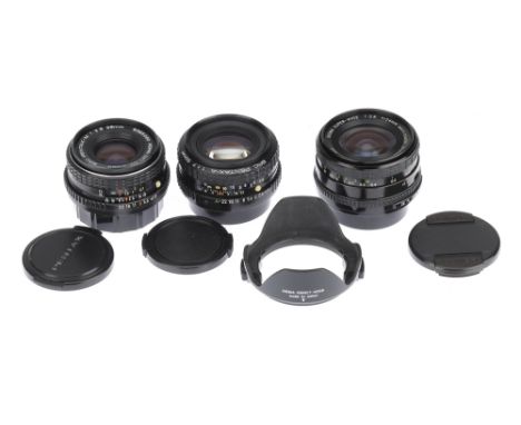 Three Pentax K Mount Lenses comprising a SMC Pentax-A f/1.7 50mm lens, a SMC-Pentax-M f/2.8 28mm lens and a Sigma Super-Wide 