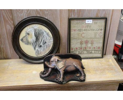 A small 18th century sampler, together with a reproduction carved elephant from Exeter Cathedral, and an oak framed watercolo