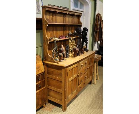 A stripped Ercol oak dresser, with twin shelved plate rack back, over four central drawers flanked by two cupboard doors