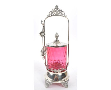 A 19th century Victorian silver tone metal and cranberry glass pickle castor decanter. The castor raised on four pierced supp