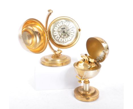 A 20th century desktop gilt metal globe clock and table lighter. Each piece raised on a round stepped base, with spherical gl