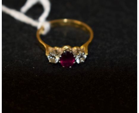 A ruby and diamond trilogy ring, central red ruby approx 0.50ct, flanked by a round brilliant cut diamond to each side, total