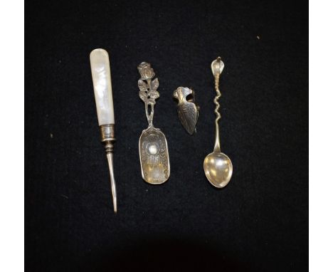 An Indian silver cobra handle spoon, stamped silver;  a rose handle caddy spoon, stamped 800;  a mother of pearl handle manic