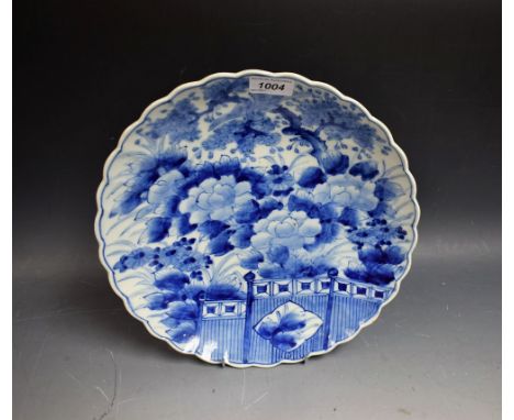 A Japanese shaped circular plate, painted in underglaze blue with flowering peonies, 30cm diam, Miji period