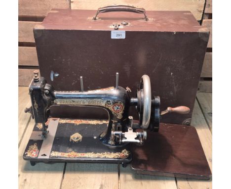 Antique Bradbury's "Soeze" hand crank sewing machine. Comes with wooden travel case.