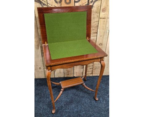 Early 20th century mahogany games table; flip top section revealing green baize interior. Comes with various playing cards.