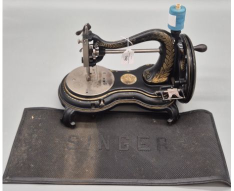 An Antique Jones Serpent or Cats Back Sewing Machine and Singer mat.