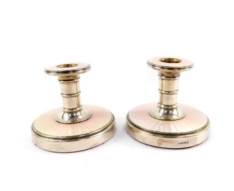 A pair of silver candlesticks, with white to pink guilloche enamel decoration, S J Rose &amp; Son, London 1958, 8cm H, 12.31o