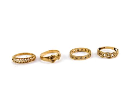A 9ct gold belt and buckle ring, size L, Celtic knot ring, size N, eternity band, size K, and a 9ct gold dress ring, size N, 