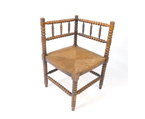 A Victorian bobbin turned corner chair, with a rush seat, the legs united by stretchers.