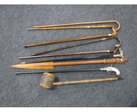 Two bundles of assorted walking sticks including examples with silver mounts, pistol handled stick etc together with a tribal