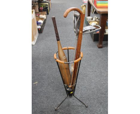 A mid twentieth century stick stand with two sticks and shooting stick, Slazenger throwing club