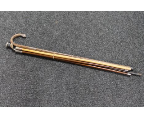 Three military swagger sticks together with a walking stick and cane with silver mounts and pommel 