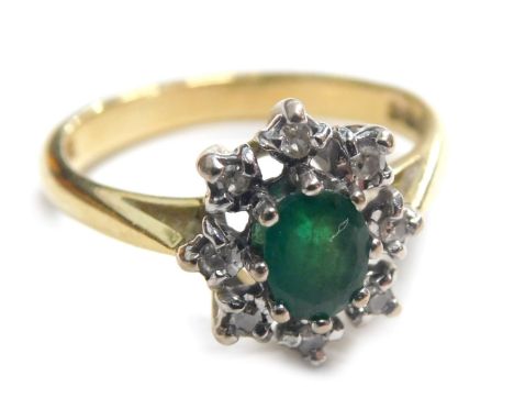 An 18ct gold emerald and diamond cluster ring, the oval emerald in claw setting with snowflake type diamond 8 point border, i