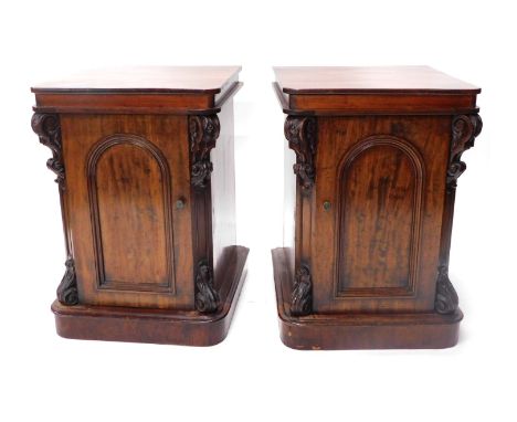 A pair of Victorian mahogany cabinets, each with a square top with rounded corners, with applied scroll caryatids and single 