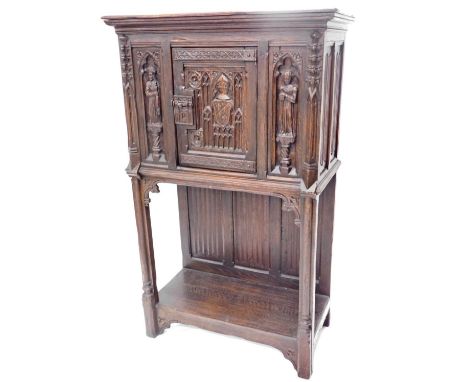 A 19thC oak carved gothic cabinet, the rectangular top above a carved and frieze door, with two figure caryatids, and a lower