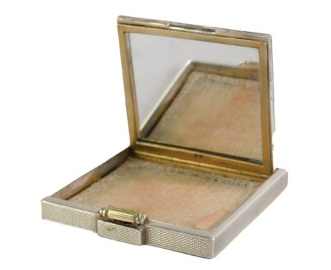 A George VI silver compact, of engine turned plain decoration, with silver gilt scroll clasp, with mesh interior and mirrored